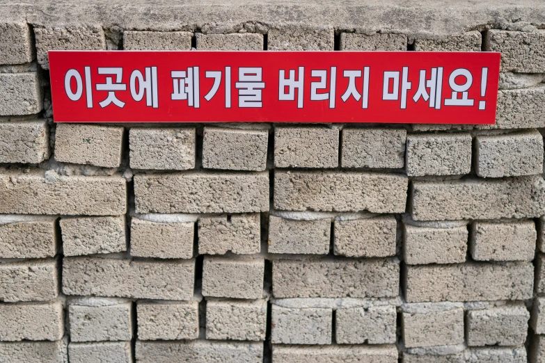a sign that is on the side of some kind of brick wall