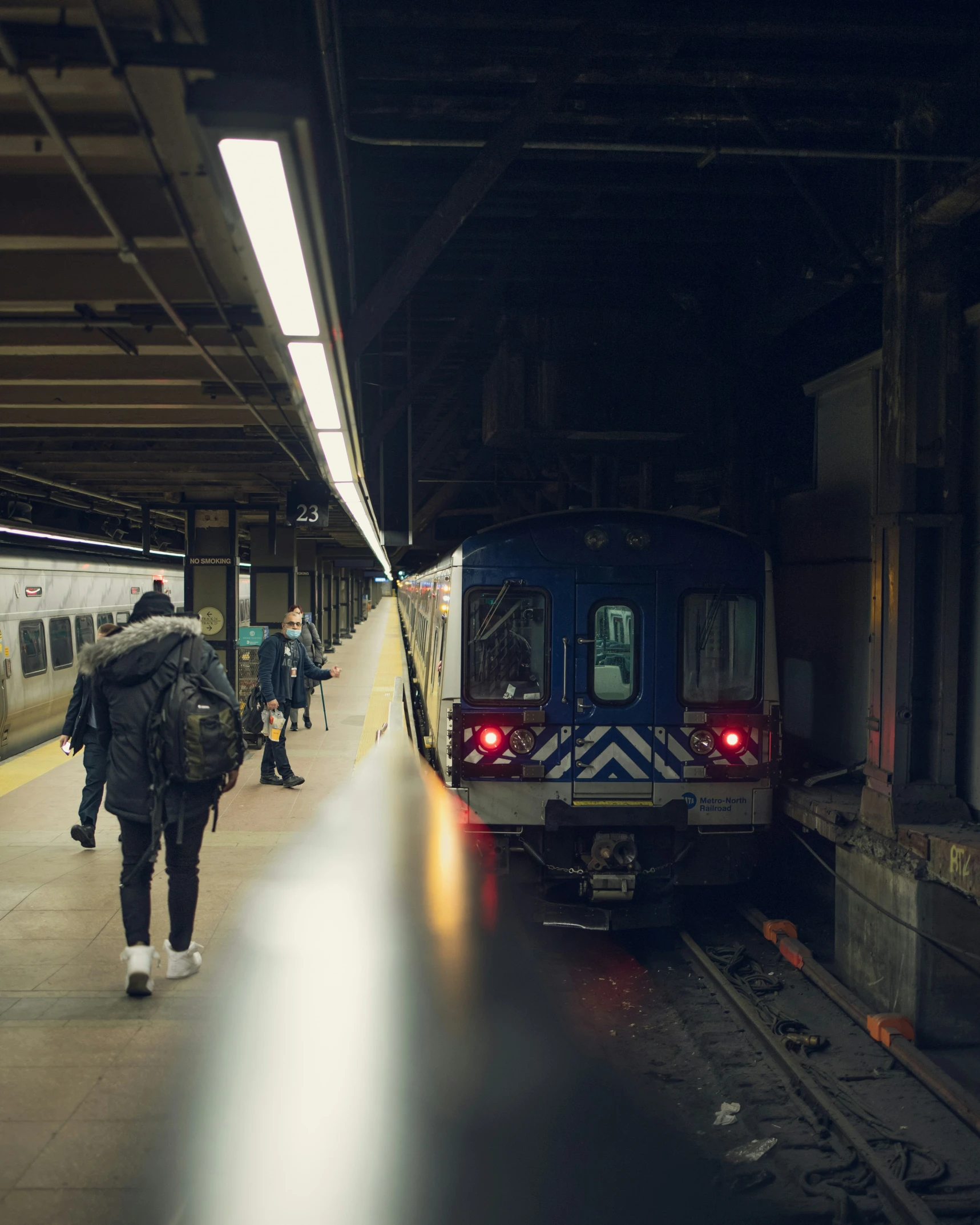 the people are standing on the platform waiting for their train