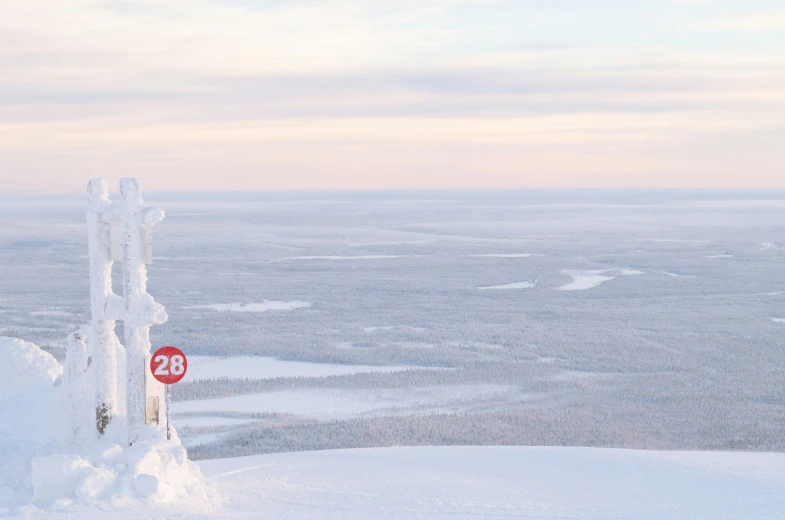 a stop sign stands covered in snow as it looks towards the distance