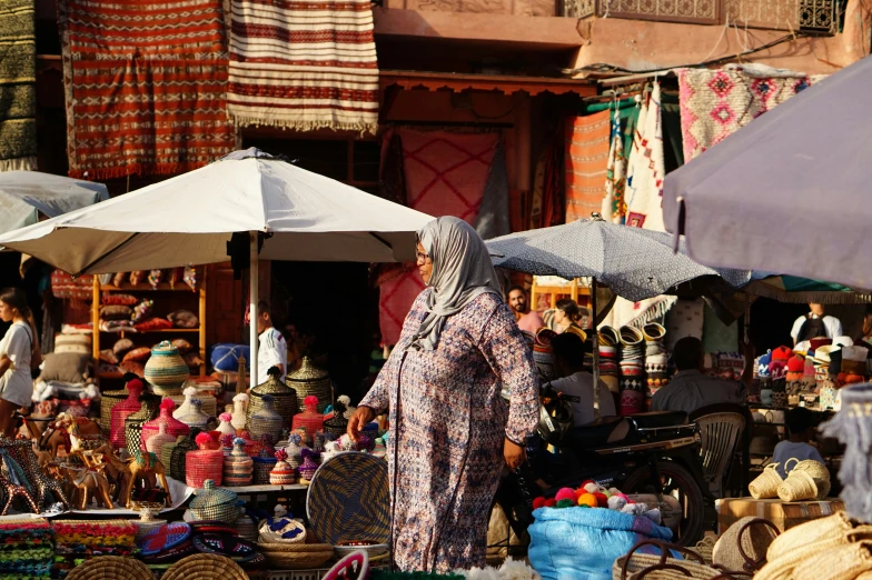 an oriental lady walking through a crowded outdoor market