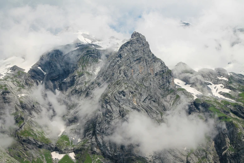 some snow covered mountains with a very cloudy sky