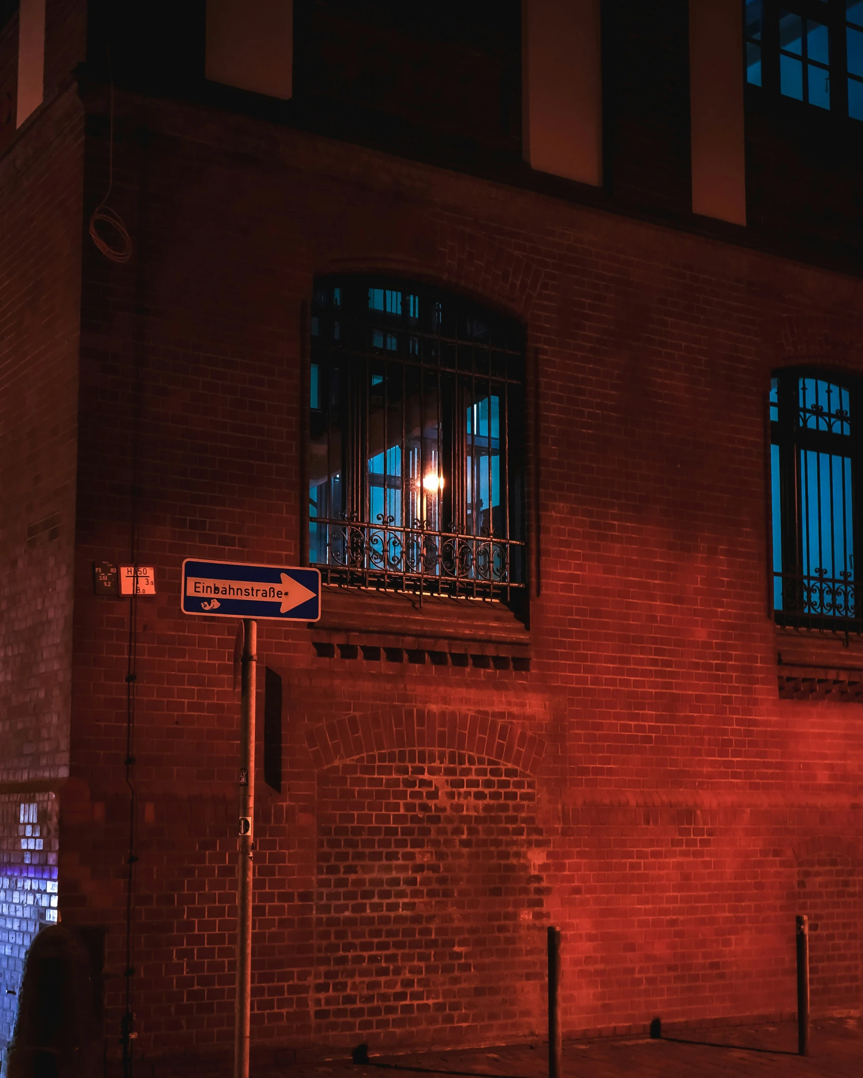 a brick building with street signs and a sign with a blue light