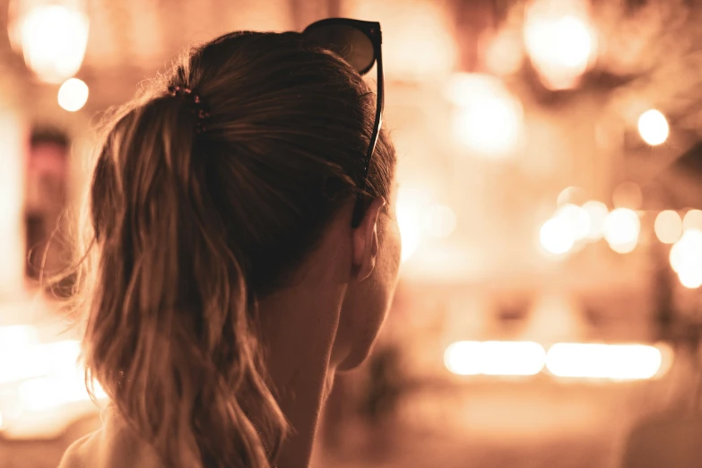 a woman looking out of her window in the evening