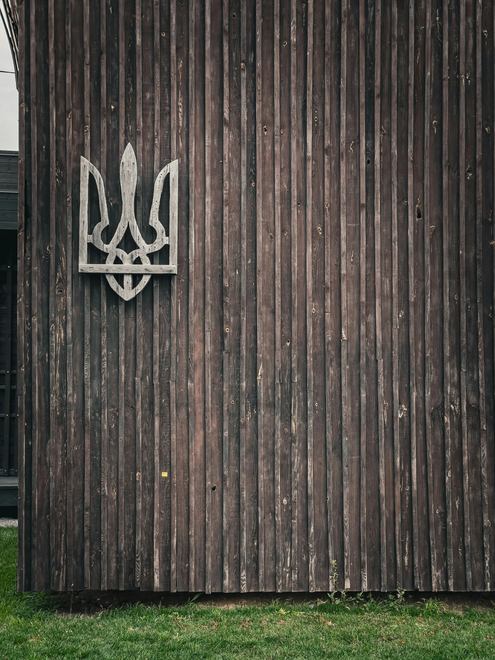 the door is made out of wood and has a metal logo