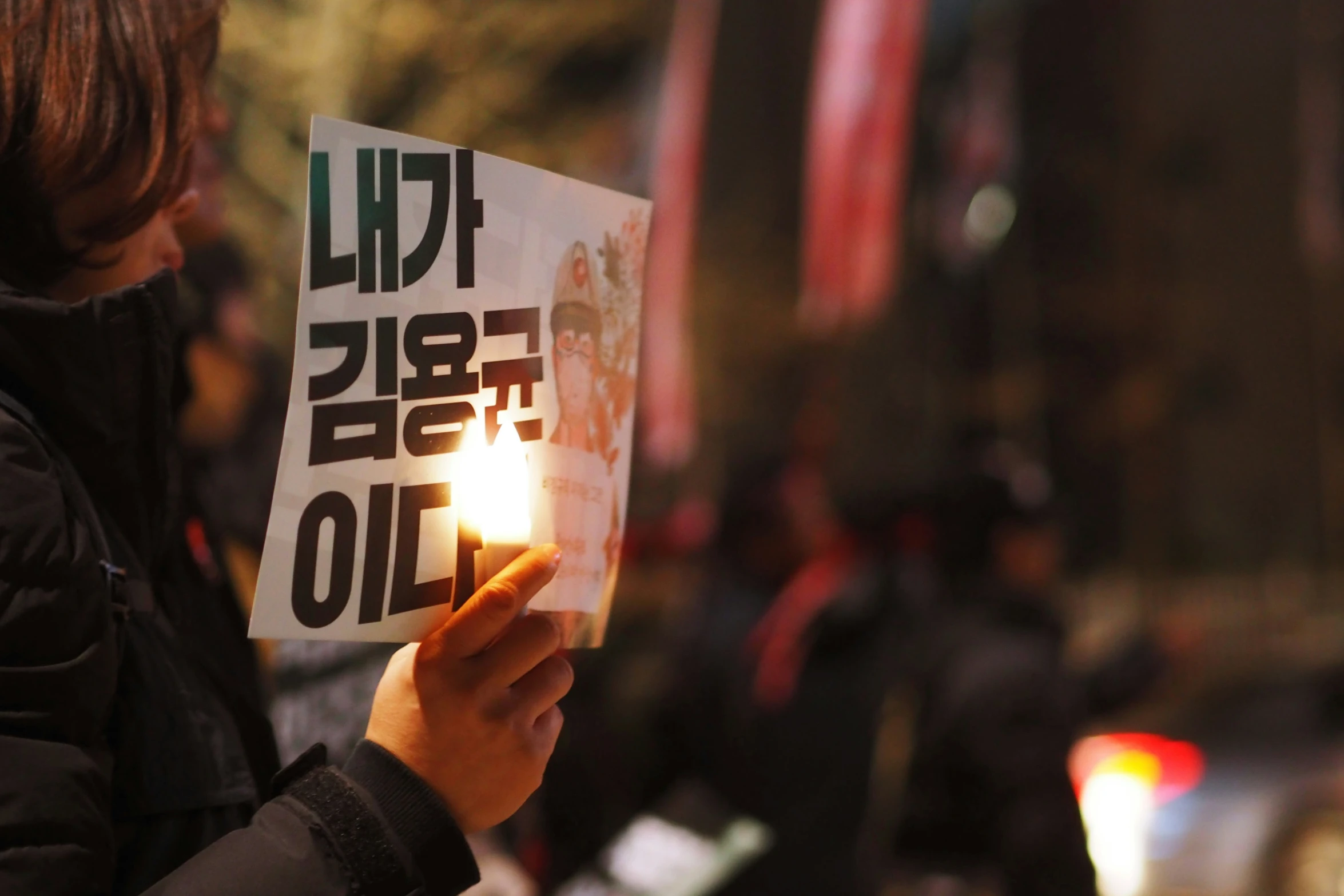 a woman holding a protest sign next to some buildings