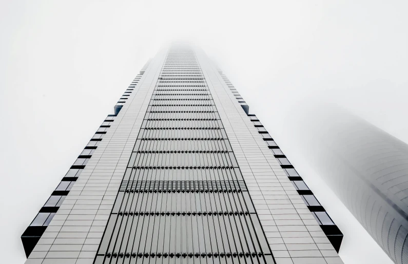 tall buildings sit behind a thick, white, fog