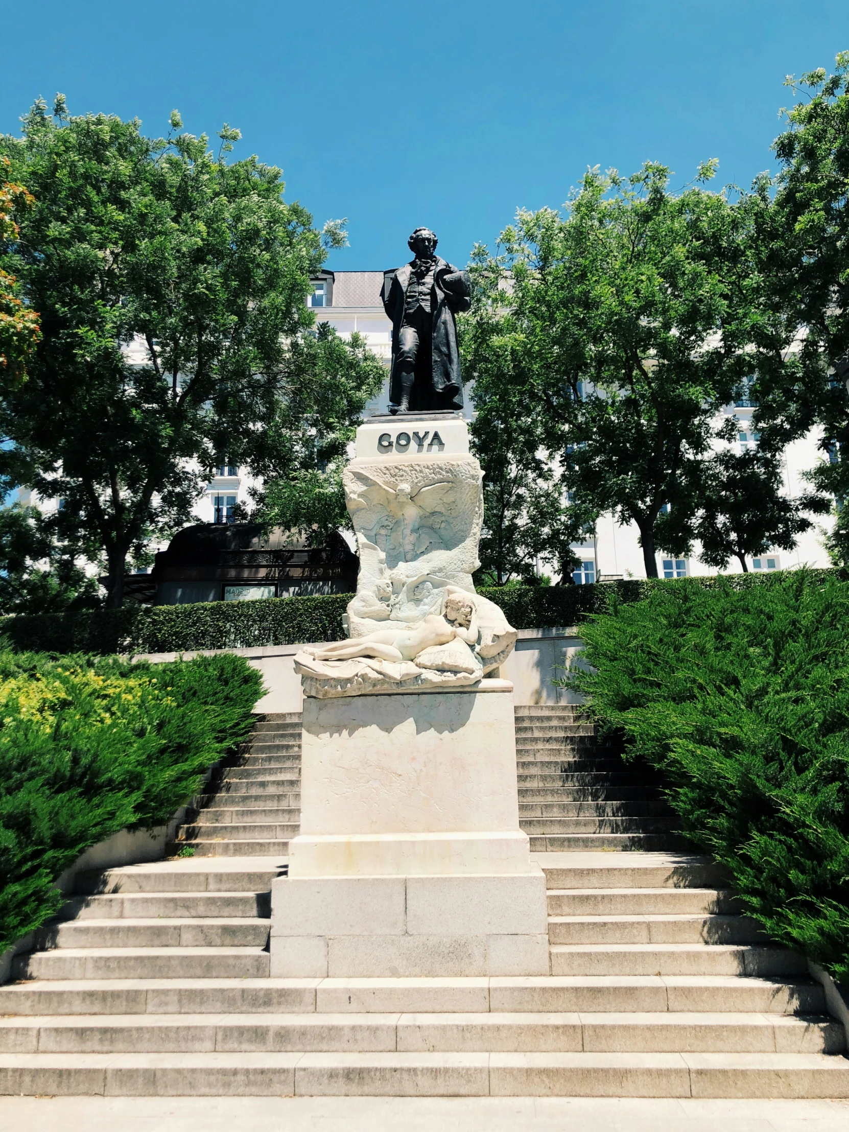 a bust sits at the foot of stairs with a clock above it