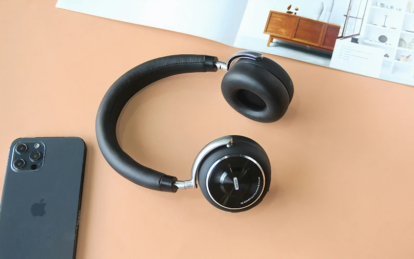 a couple of headphones laying on top of a desk next to a samsung phone