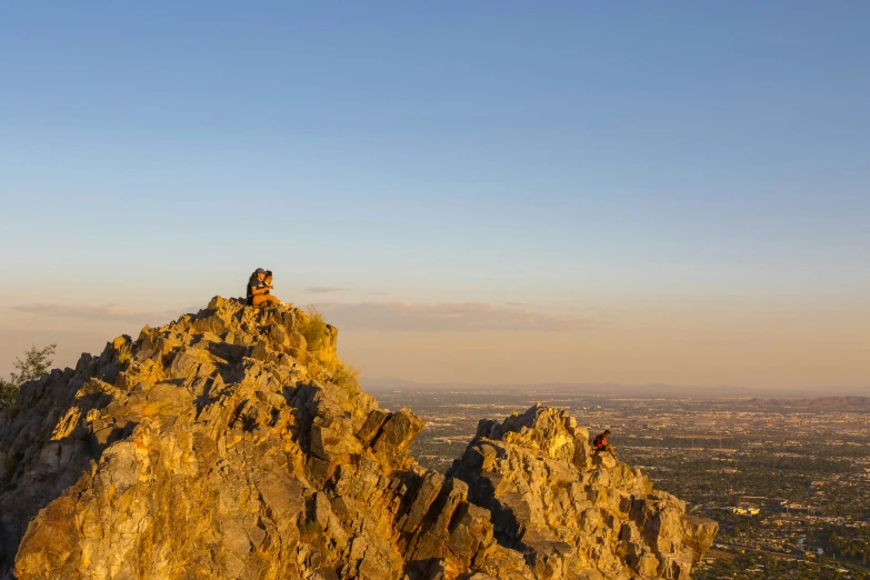 a couple of people are standing on top of a mountain