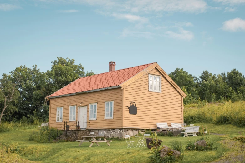 a yellow house with windows and some chairs outside