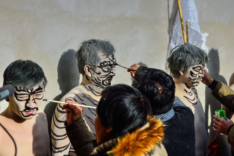 several people wearing various skin and face painting on them