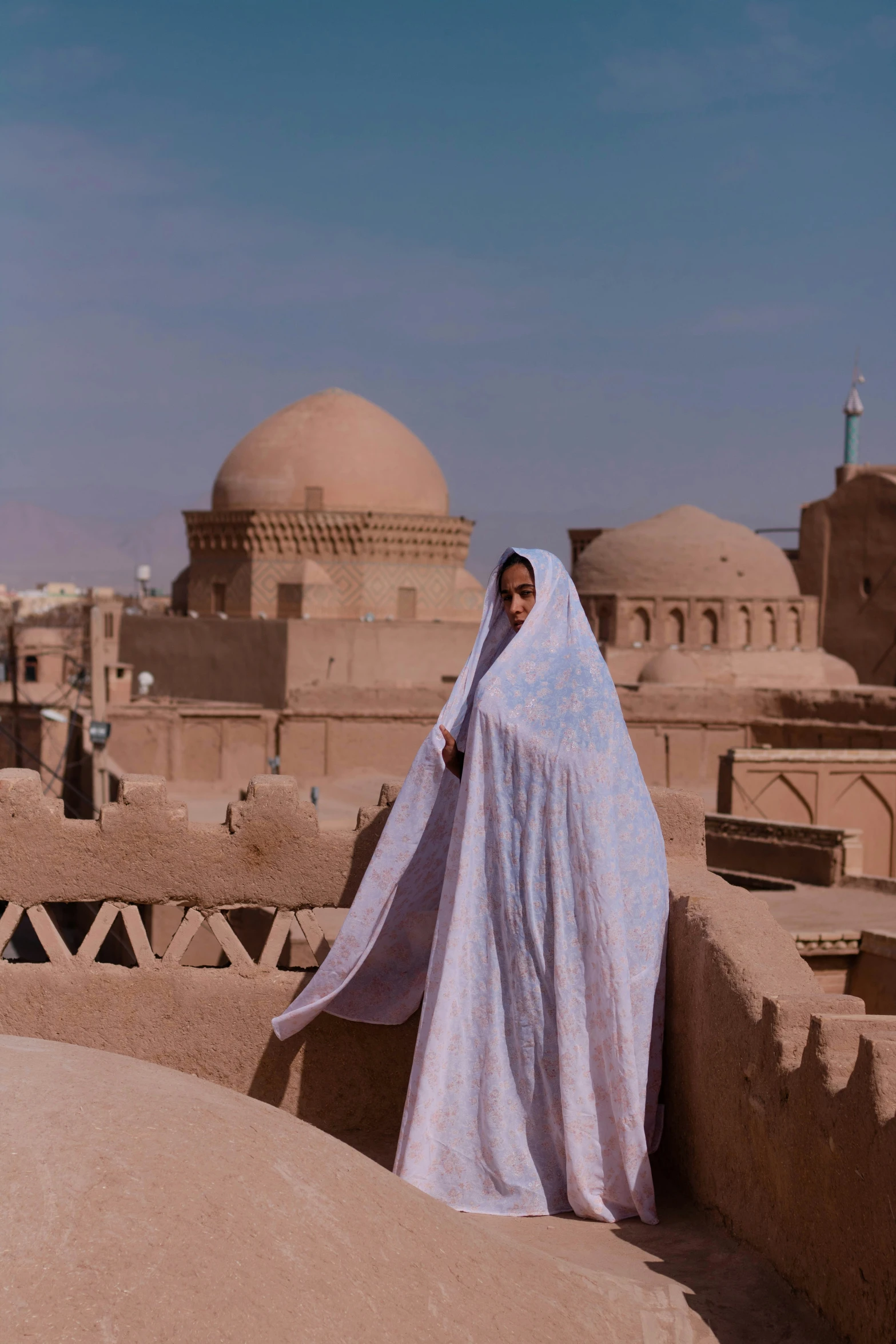 a woman in a blue and white outfit on a building wall