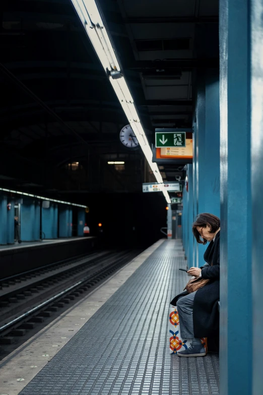 a person sits on the subway platform