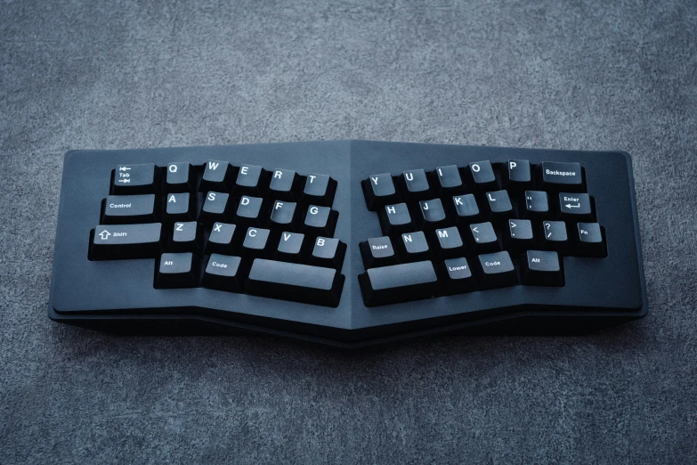 a picture of two black computer keyboards laying on a gray floor