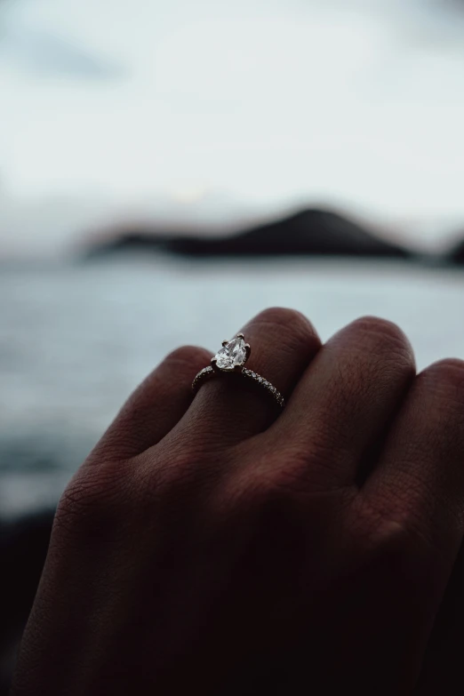 person holding up their wedding ring to the camera