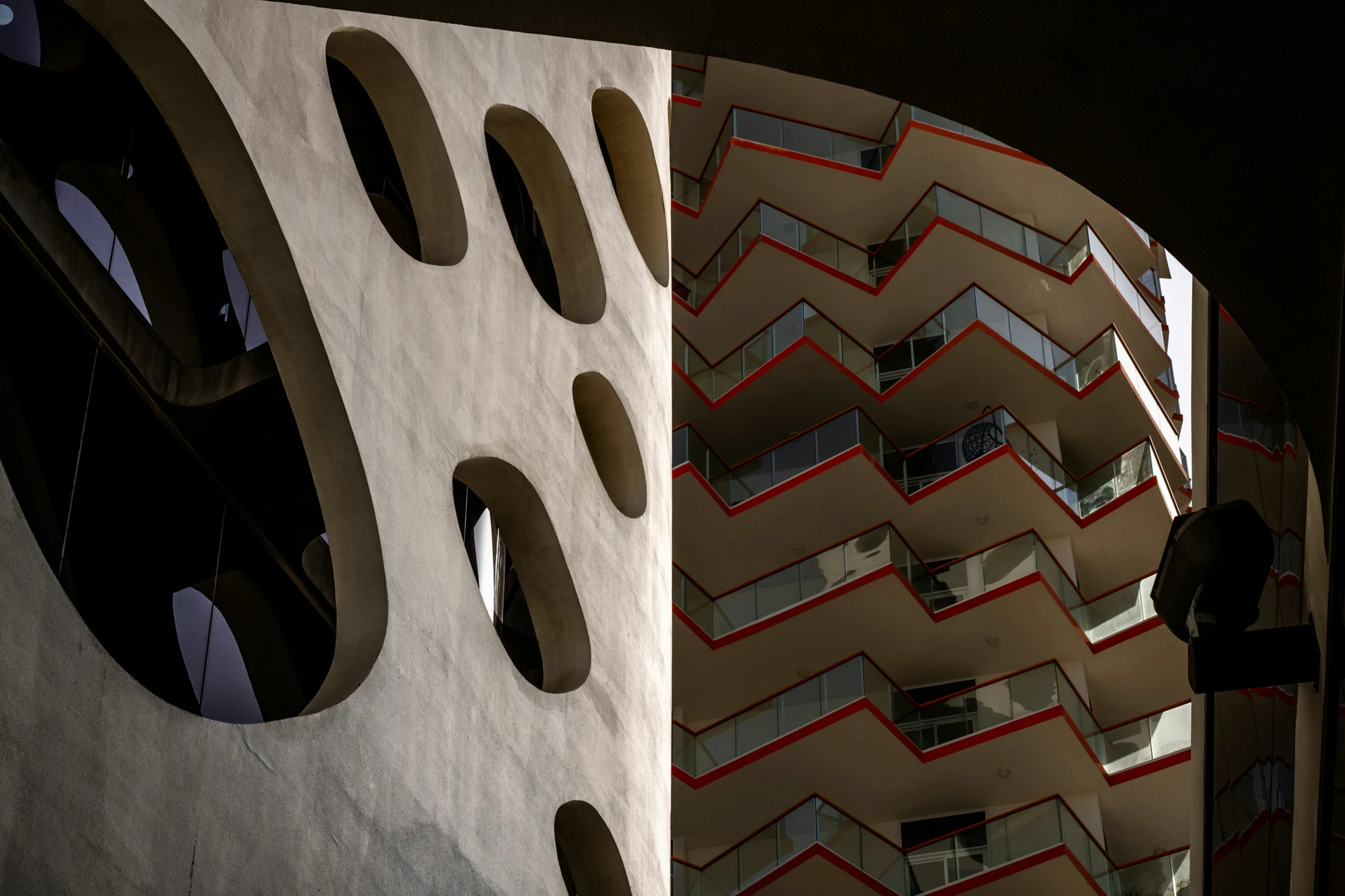 a large multi story building with multiple windows and rounded shapes