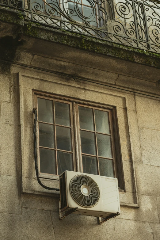 an air conditioner hanging from a window of a building