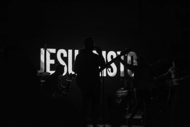 three people stand in front of a projection of jesus's creation