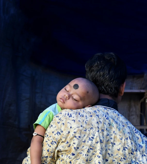 a person wearing a small doll and holding the woman