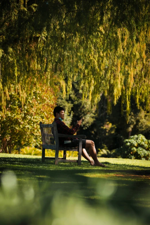 the woman sitting on the bench is talking on the phone