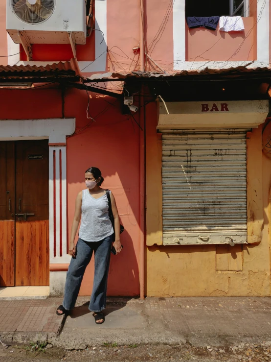 a woman leaning against a building holding a baseball bat