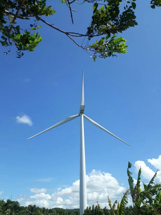 the wind turbine in the distance looks like it could become a giant, white tower