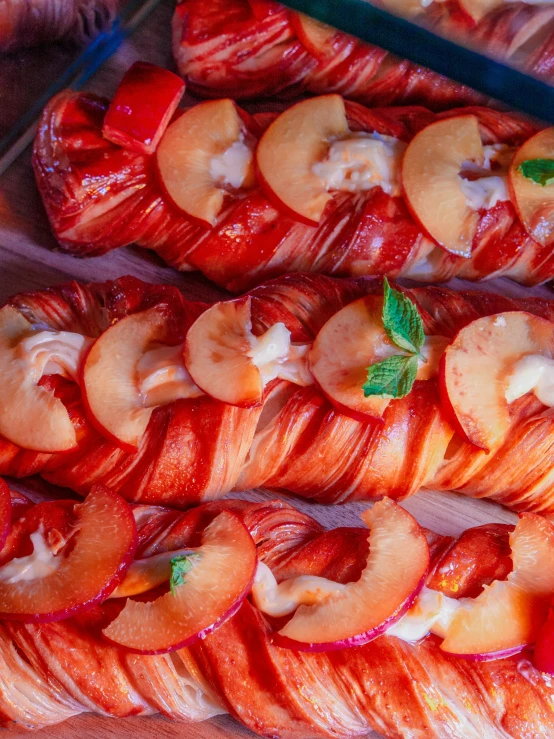 a wooden tray topped with sliced fruit covered in cream