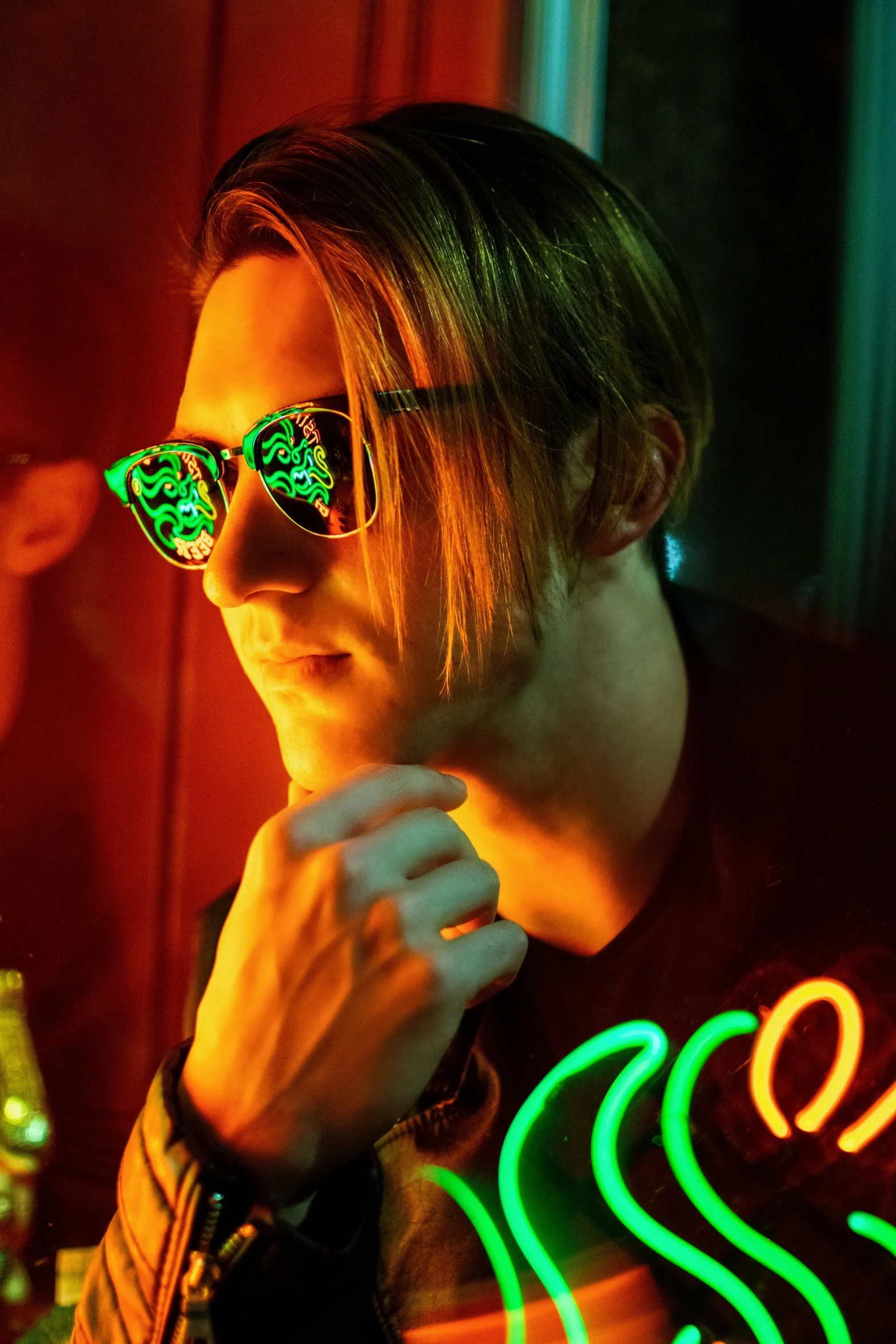 man in neon glasses looking up at the camera