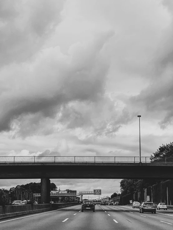 a street with an overpass in the middle and a cloudy sky