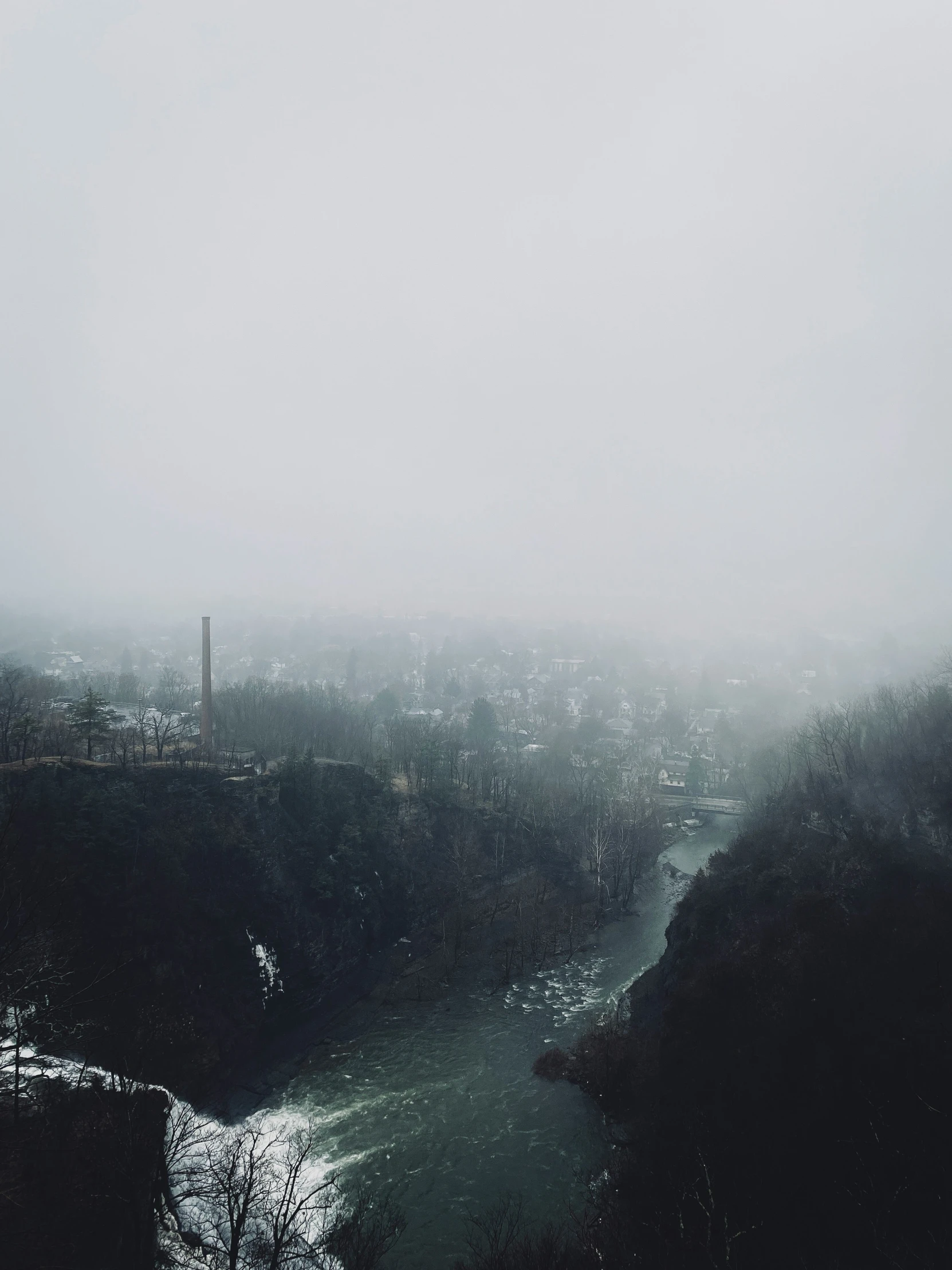 the river and cityscape are shrouded with dark fog