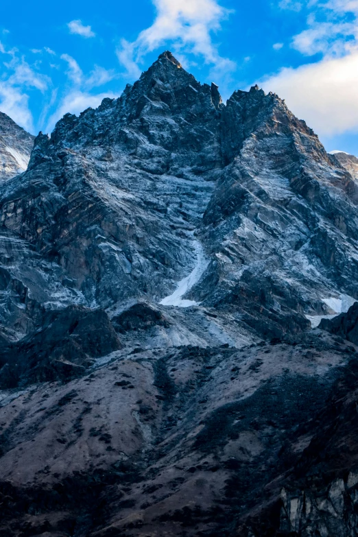 a mountain range with snow, clouds and grass