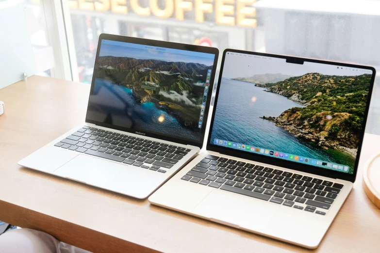 two laptop computers, one with an iphone next to the other with an image on the screen