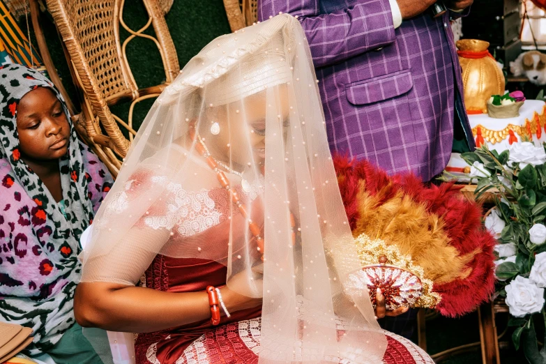 a woman in a wedding veil sitting with another women