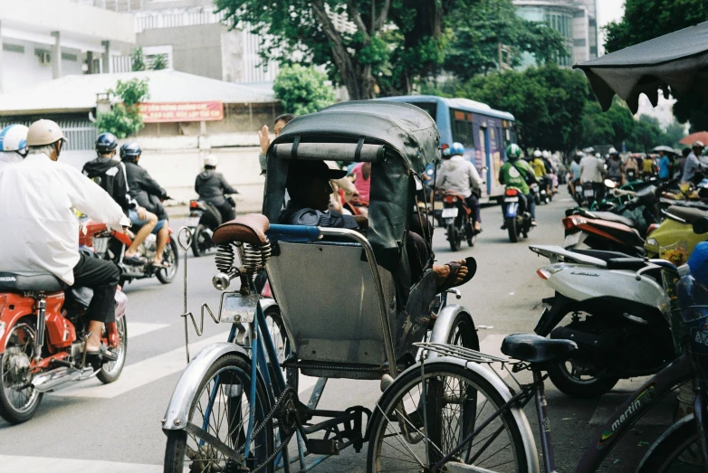 a group of people on bikes and motorcycles riding down a street