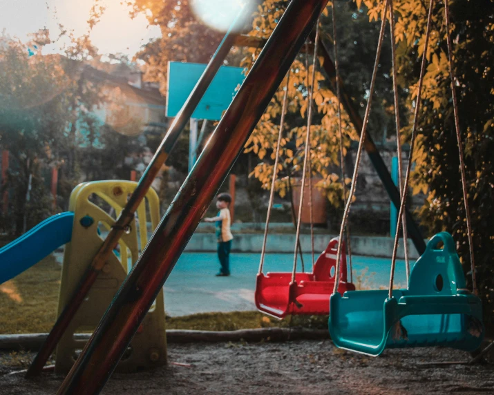 childrens park swings set next to playground in urban area