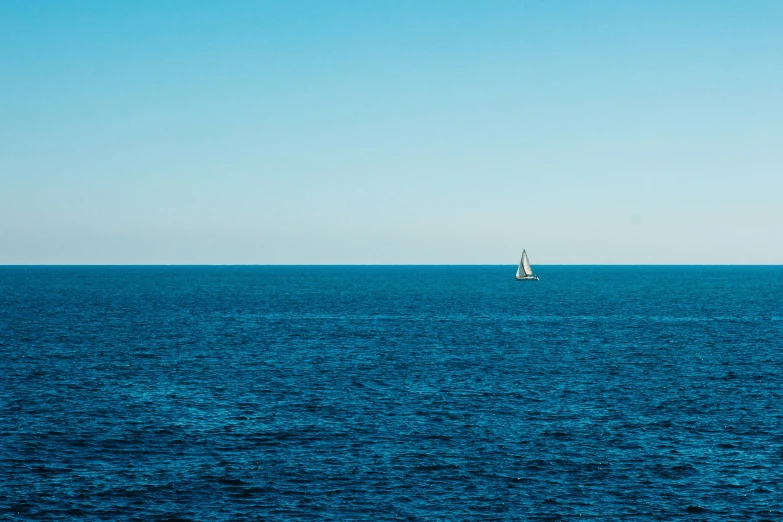 a sailboat floating in the middle of the ocean