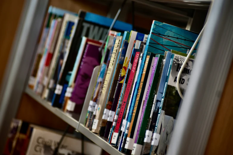 a book shelf with many books and one hanging from the top