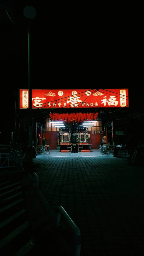 a night time scene shows an illuminated theater entrance