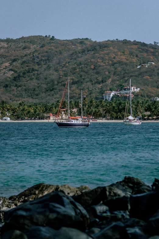 the boat is in the water with a mountain behind it