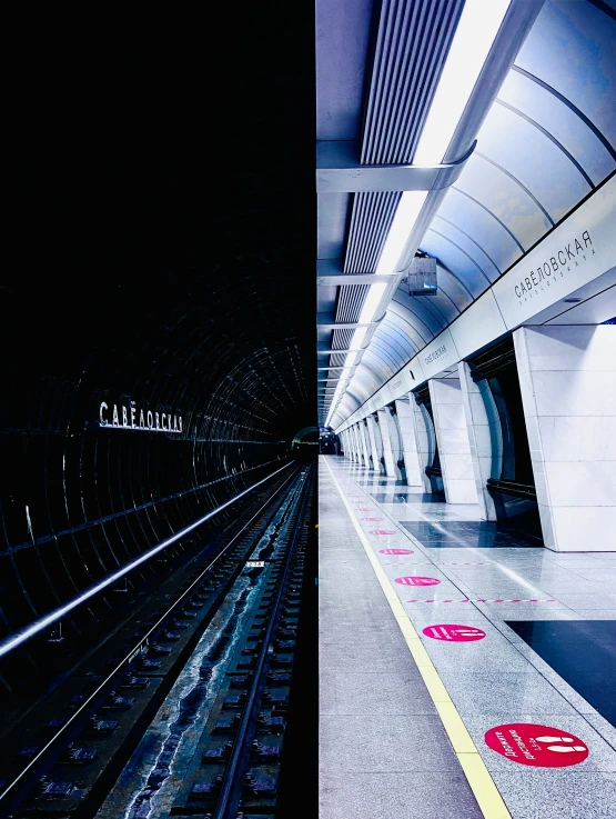 a subway station with a train platform with tracks