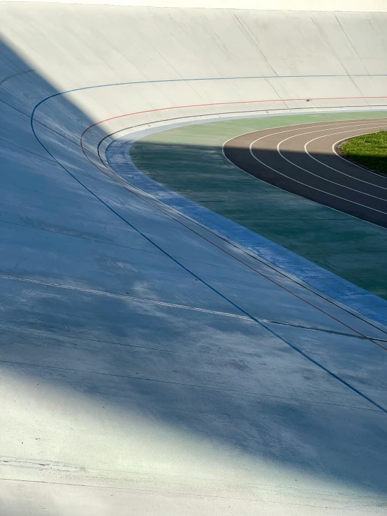 an empty road on top of some green hills