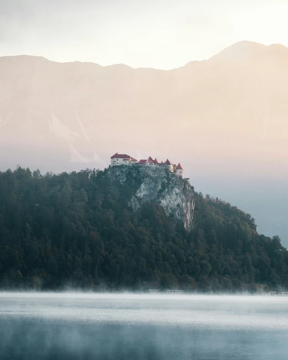 castle perched on a hill with mist rising in the air