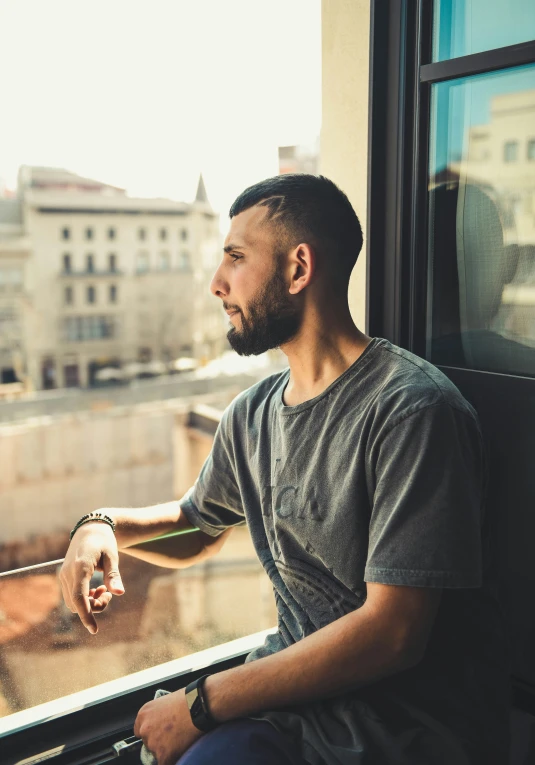 a man sitting in a train station looking out the window