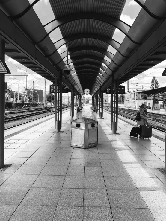 a person sitting on a bench near a train station