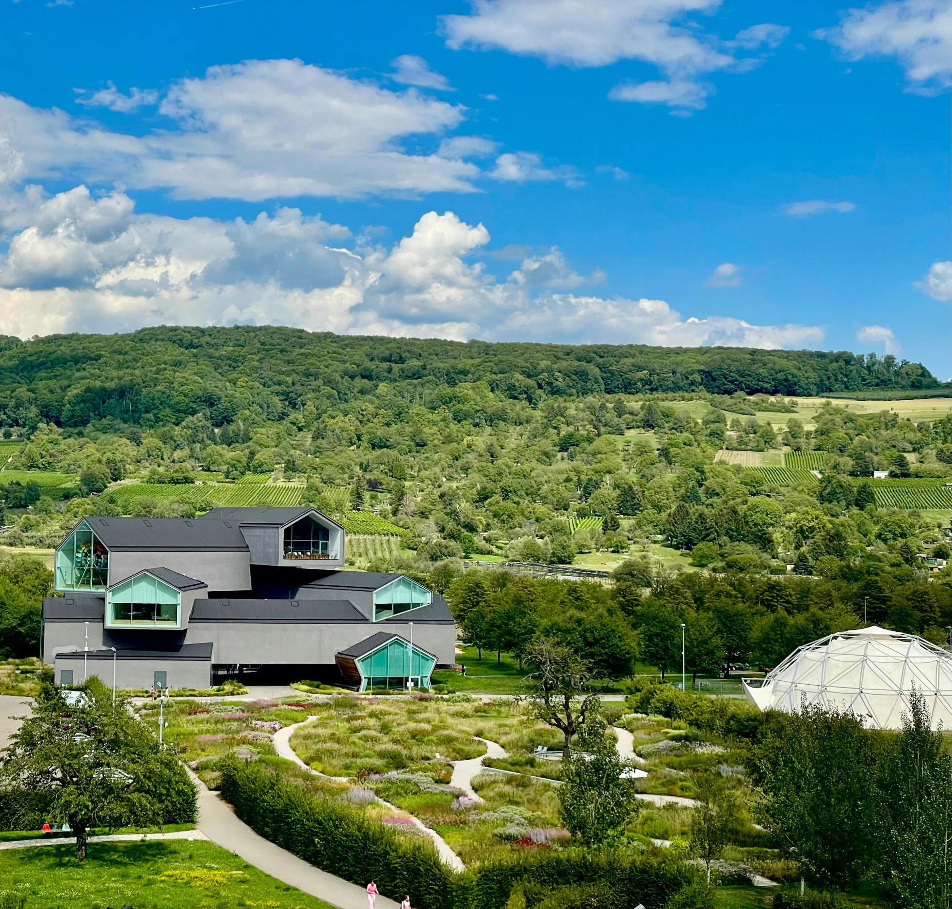 a large house on top of a lush green hillside