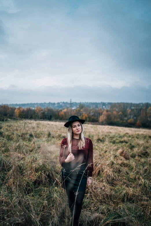 a woman standing in a field posing for a picture