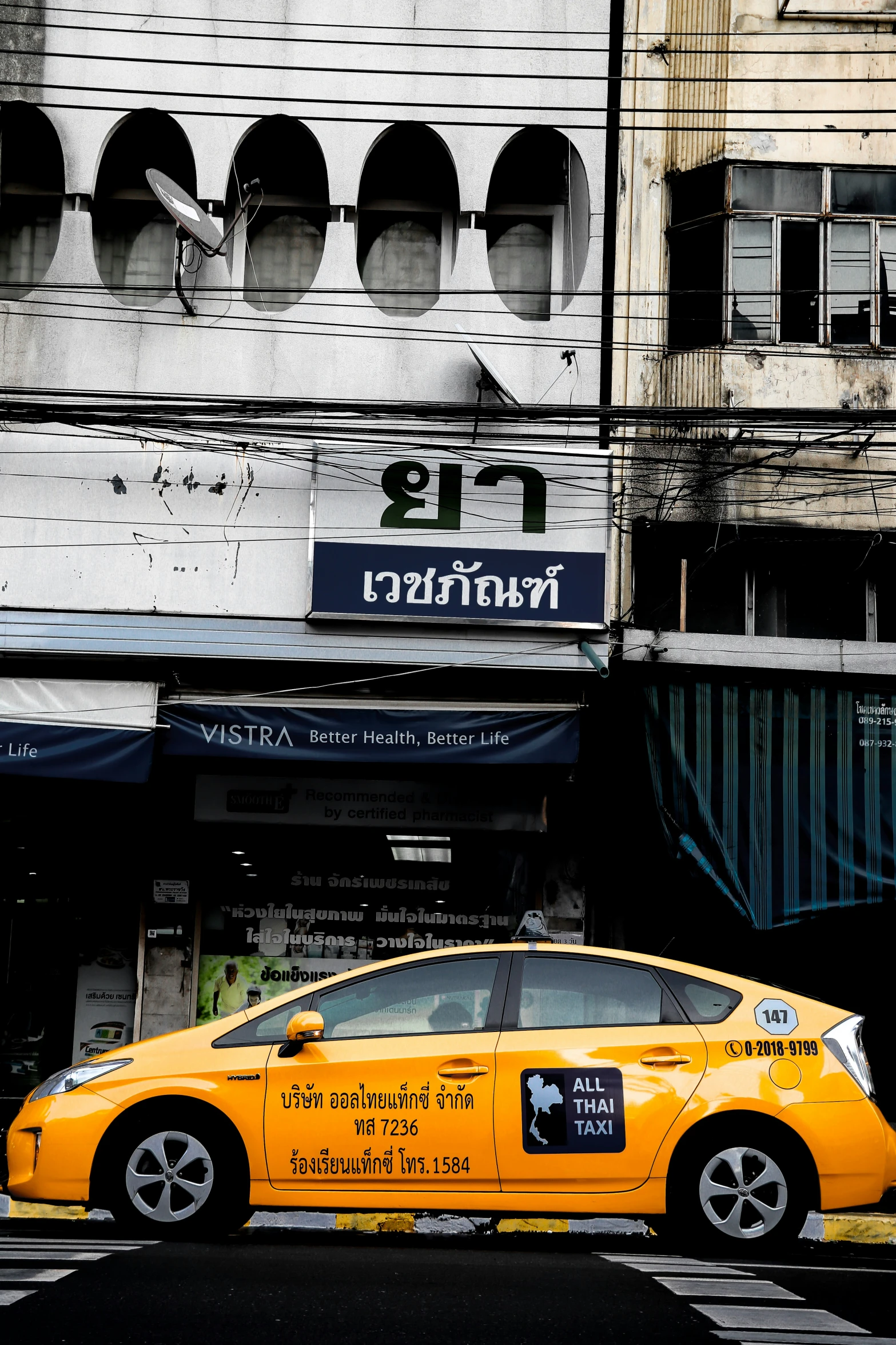 a yellow taxi cab in front of a city building