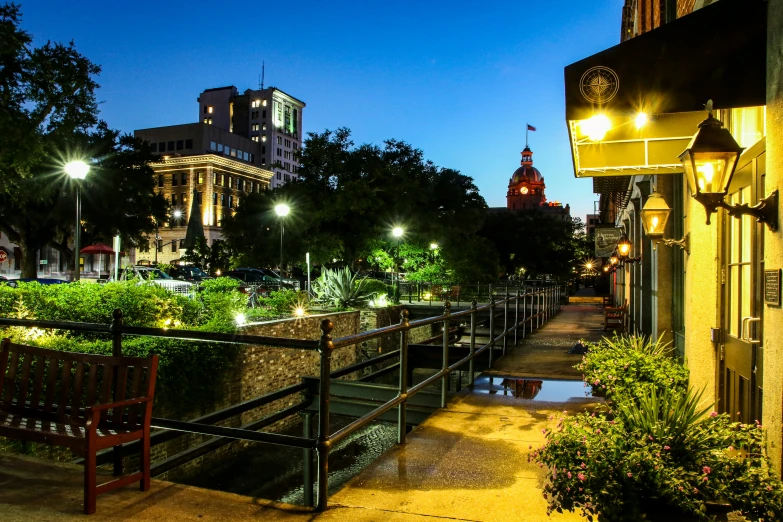 bench on sidewalk area with lights at night