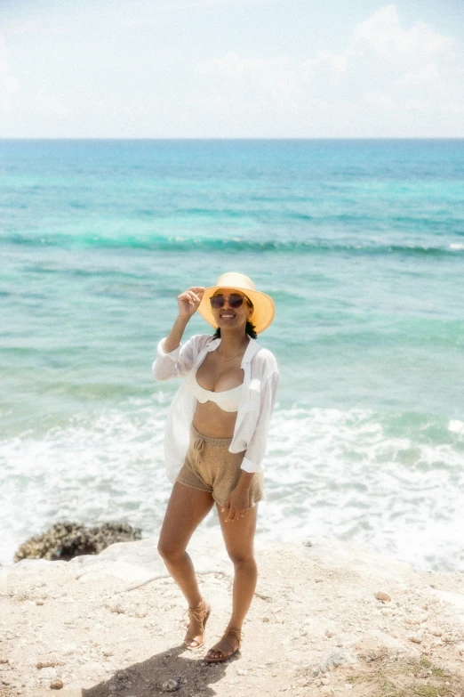 a woman standing on top of a sandy beach next to the ocean