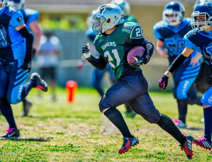 children in uniforms running on a football field